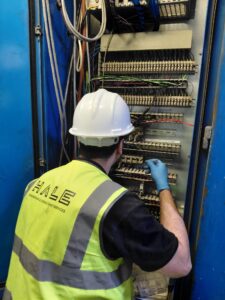 Hale Engineering engineer inspecting control panel wiring, terminals and PLC I/O connections during a legacy Siemens 505 PLC and WinCC SCADA fault-finding project.