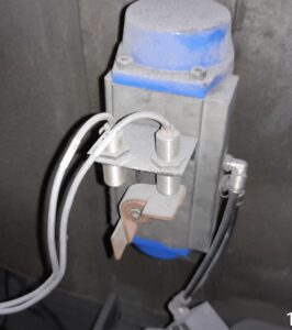 Pneumatic rotary actuator fitted with proximity sensors and air connections on industrial processing equipment.